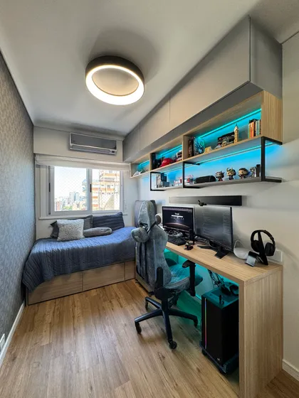 Habitación moderna con zona de gaming y cama, iluminación LED — proyecto Libertador II, por MDBK Arquitectura, en Núñez