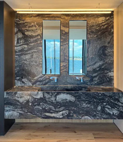 baño moderno con doble bacha de piedra y detalles de iluminación — proyecto Casa ENE, por Jorgelina Tortorici & asoc., en Nordelta