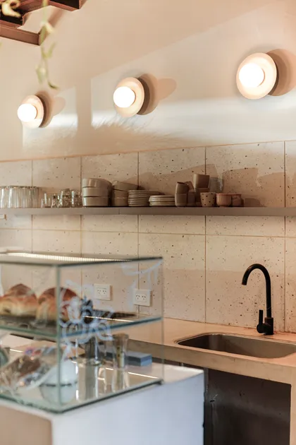 Cocina moderna con estantes abiertos, luces redondas y grifo negro — proyecto La Selva Yoga - Cafe, por Jeitinho Estudió Creativo, en La Plata