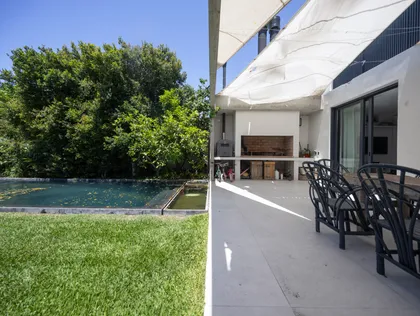 Pileta y parrilla moderna rodeada de verde — proyecto CASA OrBa, por Alfredo Orfila arquitectura, en San Isidro