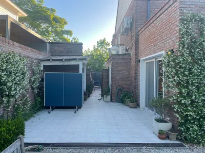 Patio con mesa de ping pong y paredes de ladrillo a la vista — proyecto Obra La Posta, por Arq. Lourdes Yarade Saravia, en Pilar
