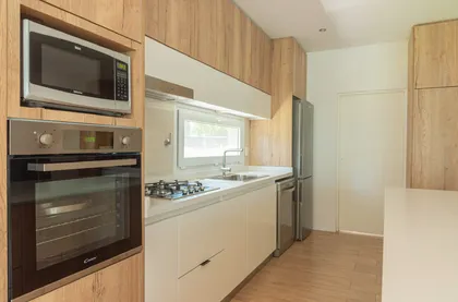 Cocina moderna con muebles de madera natural y electrodomésticos integrados — proyecto Reforma cocina , por Metro creativo , en Belén de Escobar