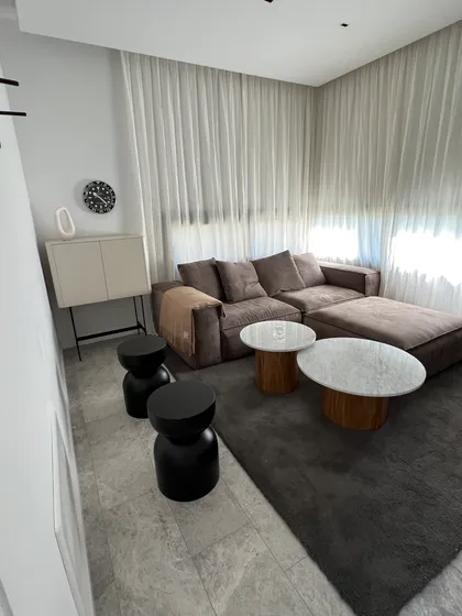 Living moderno con sofá gris, mesas auxiliares y cortinas blancas — proyecto CASA LR427 - SOFITEL LOS CARDALES, por Carolina Depetris, en B2814 Los Cardales