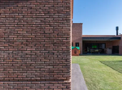 fachada moderna de ladrillos con jardín — proyecto VIVIENDA L.L, por Lorenabusquetsarquitectura, en Córdoba