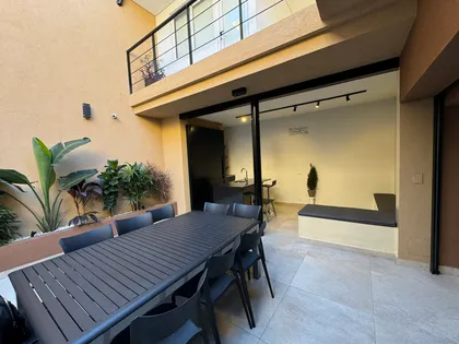 Patio moderno con comedor exterior, mesa de madera y sillas metálicas — proyecto Marcelo & Majo, por Costantini studio, en Buenos Aires