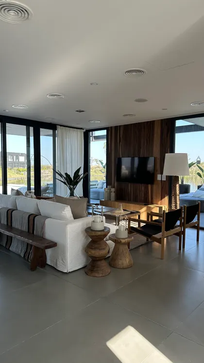 Living moderno con ventanales y pared de madera — proyecto Showroom Casa Mies, por Alejandra Nusenovich, en Belén de Escobar