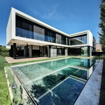 Casa moderna con piscina infinita y fachada contemporánea — proyecto CASA WINDBELLS, por ABAD GADANO, en Tigre