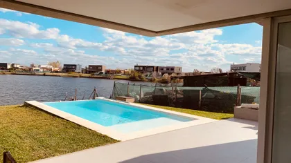 Piscina moderna y área de estar al aire libre junto al lago — proyecto Casa 33, por Guerrero Arquitectos, en Belén de Escobar
