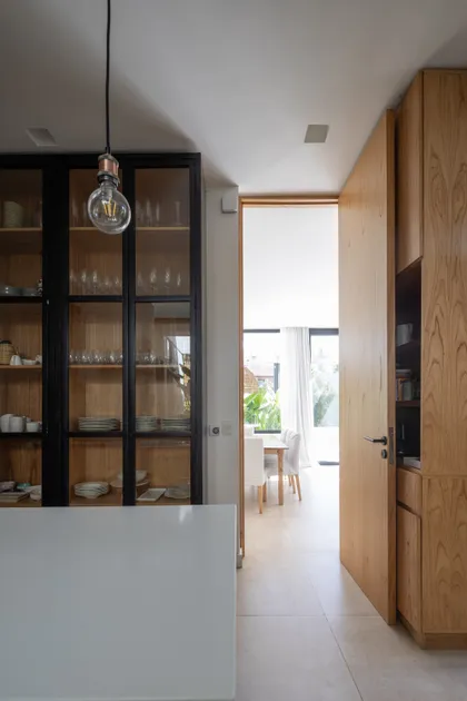 Cocina moderna de planta abierta con vitrinas y muebles de madera — proyecto CASA RuZa, por Alfredo Orfila arquitectura, en Benavidez