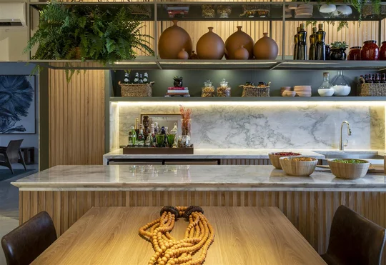 Cocina contemporánea con isla, mesadas de mármol y estantes flotantes de madera — proyecto Refugio do Forte, por Milcent Arquitetura