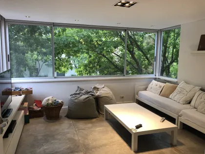 Living moderno con ventanales al bosque y pisos de cemento — proyecto MLS3 - Casa en Santa Bárbara, por MLS Estudio, en Benavidez