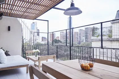Terraza moderna con techo de madera y vista urbana — proyecto UGARTECHE, por Estudio Trama, en Palermo