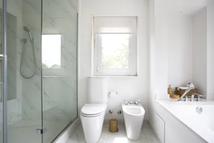 Baño moderno con mármol, bañera exenta y gran ventana — proyecto Casa W, por Estudio Junor, en Ayres de Pilar Barrio Cerrado