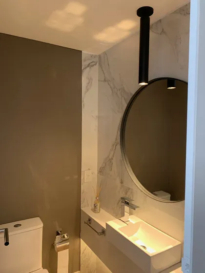 Baño moderno con mármol, lavabo rectangular y espejo redondo — proyecto Piso en Nuñez, por Gutman+Lehrer Arquitectas, en Núñez
