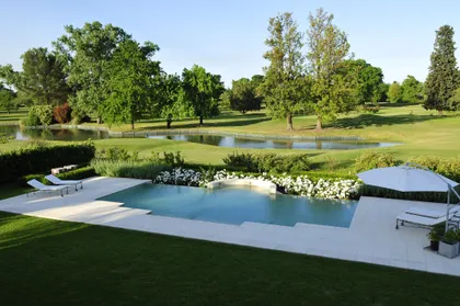 piscina infinita moderna con deck de madera y vegetación exuberante — proyecto Desde La Toscana, por Oppel Arquitectura