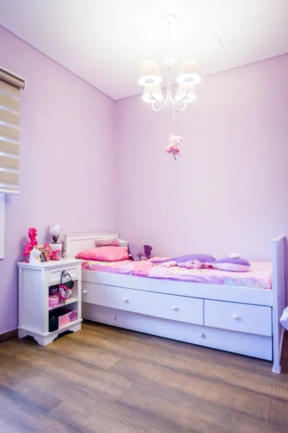 Dormitorio infantil en tonos pastel con cama baja y cómoda blanca — proyecto La casa del árbol, por Estudio Fernandez Long & asoc., en Canning