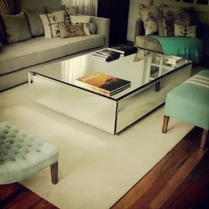 Living con mesa de centro espejada y sofá beige — proyecto Casa VG, por Vicky Hurrell, en Mar del Plata