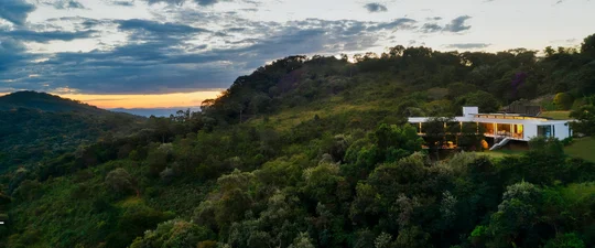 Casa moderna con terraza suspendida rodeada de naturaleza y montañas — proyecto Casa das Pedras, por Tetro Arquitetura