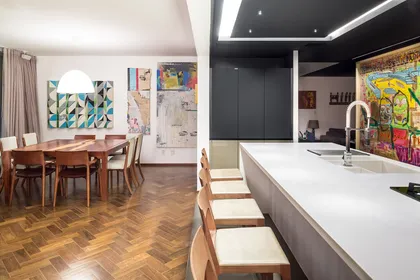 Cocina moderna con isla central blanca y piso de parquet — proyecto Apartamento 312S, por Coda Arquitetos