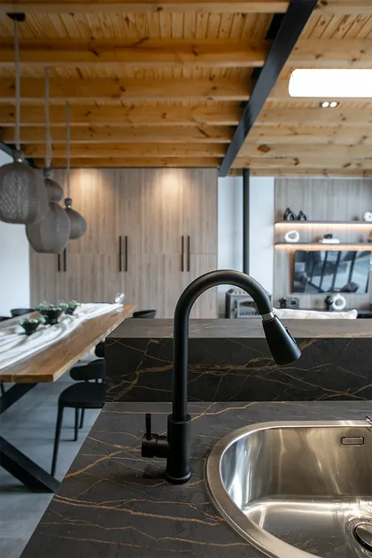 Cocina moderna con mesada de mármol negro y grifo negro mate — proyecto Casa Oroño, por Estudio Plats, en Buenos Aires