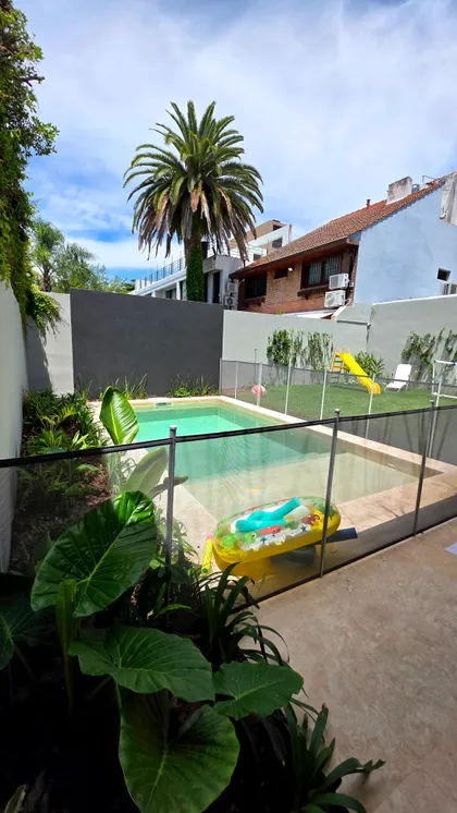 Pileta moderna con plantas tropicales y tobogán — proyecto Martinez, por Marcela García Brünner Paisajista, en Martínez