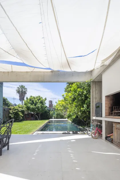 Pileta exterior moderna con pérgola de tela y parrilla — proyecto CASA OrBa, por Alfredo Orfila arquitectura, en San Isidro