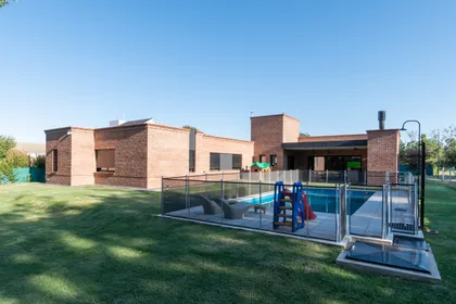 Casa moderna de ladrillo con piscina y tobogán — proyecto VIVIENDA L.L, por Lorenabusquetsarquitectura, en Córdoba
