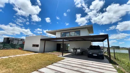 Fachada moderna con pérgola y grandes ventanales — proyecto Casa Virgi - Barrio San Sebastián (Escobar, Buenos Aires) German Salas arquitect, por German Salas arquitectura - San Is