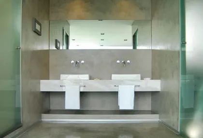 Baño moderno con lavabos integrados y paredes de microcemento — proyecto Casa JD, por Santiago Cordeyro Arquitectos, en Tigre