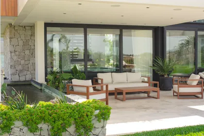Patio moderno con muebles de madera, vidrio y vista al jardín — proyecto Casa Durazno, por FeelX Tecnología SRL, en Canning