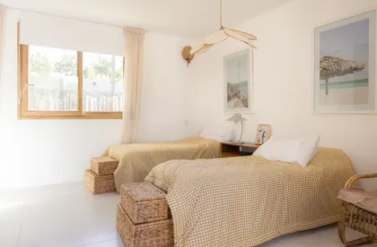 Dormitorio costero con dos camas y arte de playa — proyecto El Refugio, por Grupo Pauta Arquitectura, en Pinamar