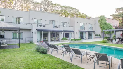 Exterior moderno con piscina y terraza de hormigón — proyecto Villa Isidro Hotel Boutique & Spa, por Hermann Arquitectos, en San Isidro