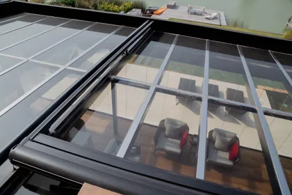 terraza moderna con techo retráctil de vidrio y muebles grises — proyecto TOLDER - TOLDOS, por Argentina en Obra 2024, en Rincón de Milberg