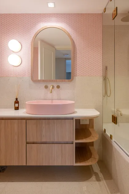 Baño moderno con lavabo rosa y mueble de madera clara — proyecto ALVEAR TYM, por AB ARQUITECTURA, en Recoleta