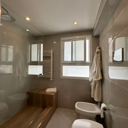 Baño moderno con bañera exenta y almacenamiento de madera — proyecto Las Heras, por MDBK Arquitectura, en Palermo