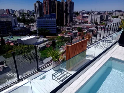 Fachada moderna con piscina y detalles de madera — proyecto Obra Urquiza 1640, por Soluciones Bralum, en Buenos Aires