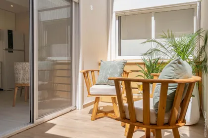 Balcón moderno con muebles de madera y plantas — proyecto Proyecto Morón, por Estudio Equilibrio, en Buenos Aires