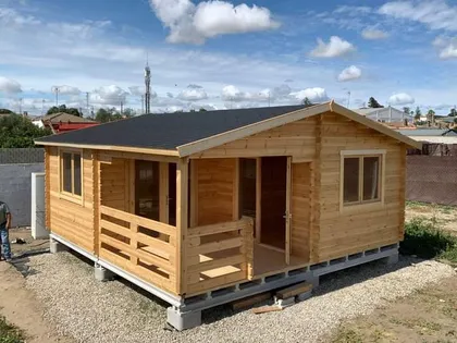 Cabaña prefabricada de madera con fachada rústica — proyecto Muelles y pérgolas , por De madera somos , en Belén de Escobar
