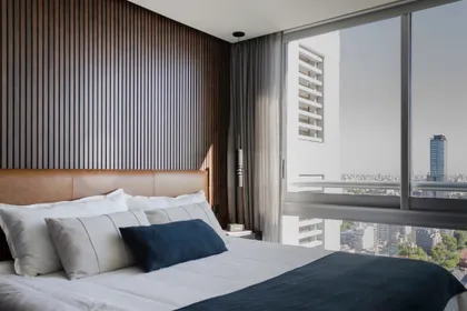 Dormitorio moderno con vista a la ciudad y detalles en madera — proyecto Varios, por Atlántica, en Buenos Aires