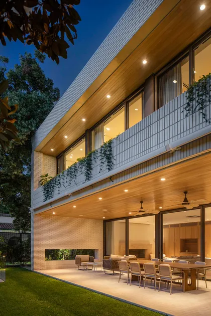 Fachada moderna con techo de madera voladizo y jardín vertical — proyecto Casa Magnolia, por Estudio PK, en San Isidro