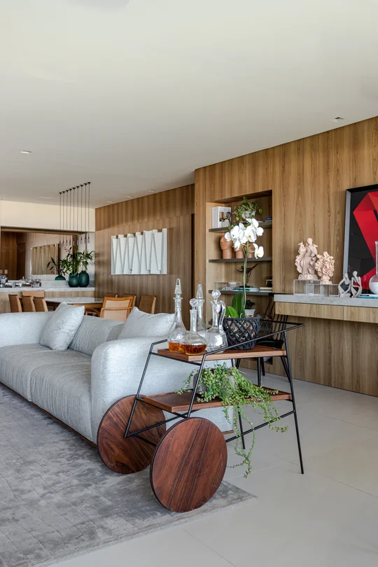 Living contemporáneo con sofá blanco, revestimiento madera y muebles diseño — proyecto Apto M | E, por Arquitetura Paulo Melo E Paulo