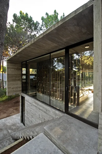 Galeria cerrada con ventanales, estructura hormigon y armazón negro — proyecto Casa Valeria, por Luciano Kruk