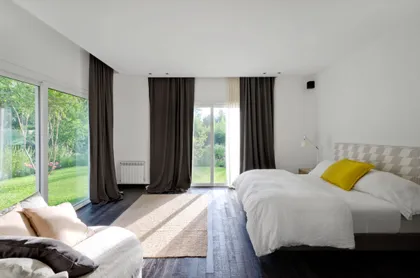 Dormitorio moderno minimalista con grandes ventanales y vegetación — proyecto Casa BA, por Estudio Dado, en Pilar