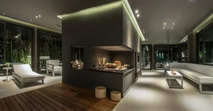 Living moderno con cocina integrada y deck en bosque — proyecto Spa Ville St Germain, por Estudio de Int Diana Gradel, en Cariló