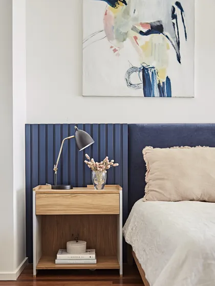 Dormitorio con panelado de madera azul, mesa de luz minimalista y cuadro abstracto — proyecto Proyecto Arboris, por URBANO estudio, en San Isidro