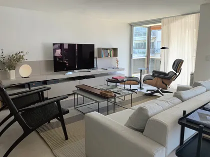 Living moderno con sillón icónico y mucha luz natural — proyecto Conde, por Bimba Estudio, en CABA