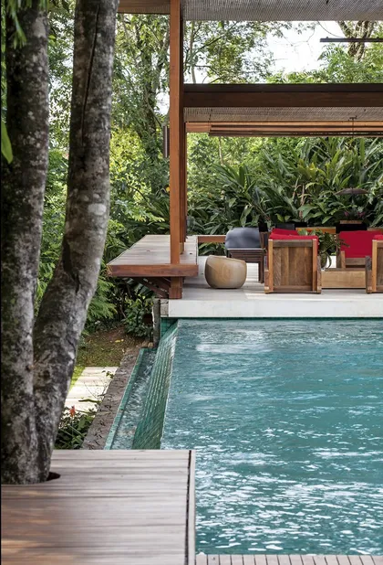 Pileta con deck de madera y pergola en selva tropical — proyecto Residência GS, por Gil Fialho