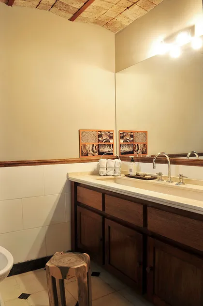 Baño rústico con techo abovedado de ladrillos y vanitory de madera — proyecto Casa en Belgrano R, por Rioja Arquitectura, en Belgrano R