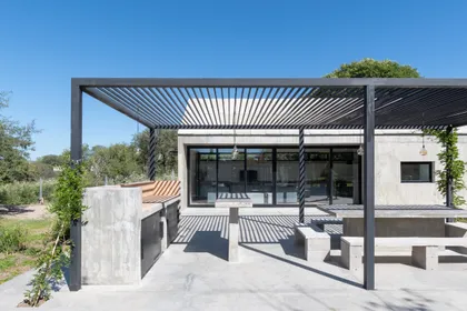 Terraza moderna con pérgola de hierro, deck y galería acristalada — proyecto Casa TT, por Grupo Studio, en Villa Allende