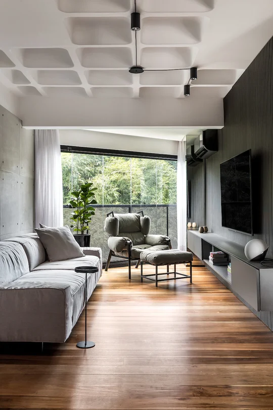 Amplio living moderno con ventanal al bosque y techo artesonado — proyecto Apartamento PF, por Boscardin Corsi Arquitetura